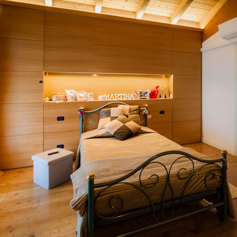 A wooden bedroom with warm natural tonalities. Functional passages and connected rooms.