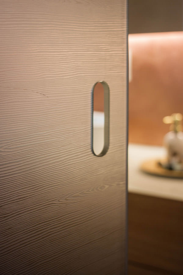 dettaglio maniglia porta scorrevole texturizzata legno vetro bagno comunicante