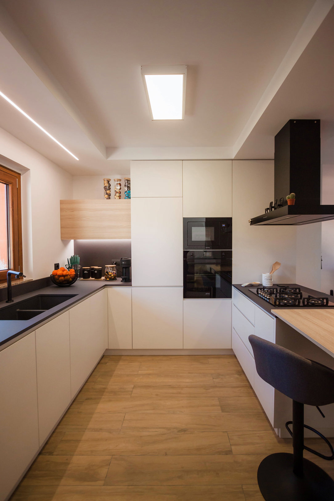 Cucina ad angolo con penisola toni di grigio legno rovere